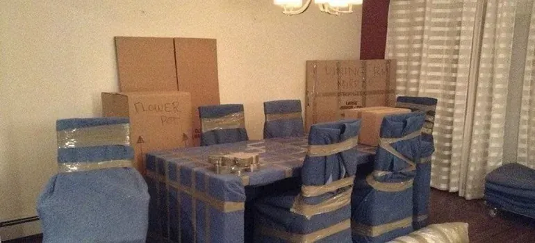 Dining table and chairs wrapped in blue pads