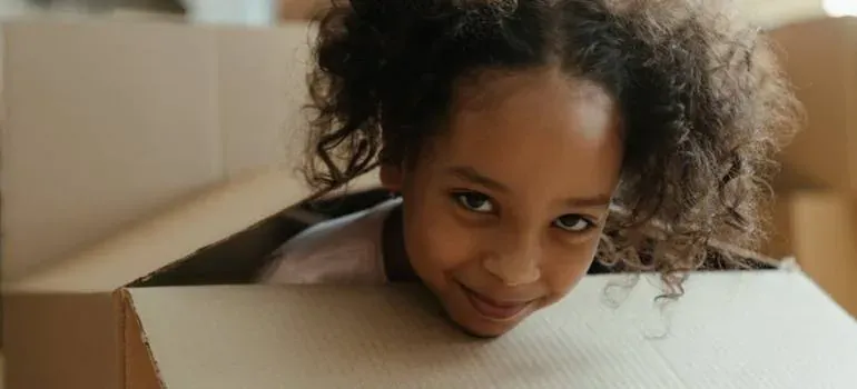 Girl peeking from cardboard box
