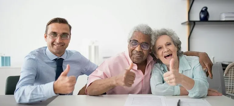 Senior couple and advisor thumbs up