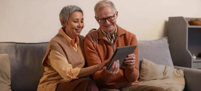 Senior couple using tablet on sofa