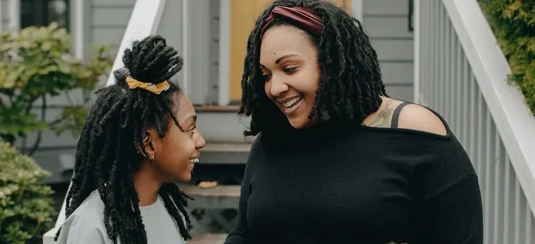 Mother and daughter laughing on porch