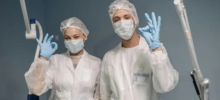 Two medical workers giving OK sign