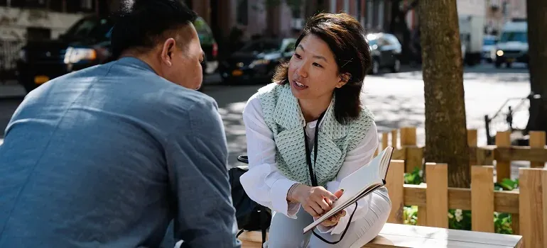 Two people talking on street bench