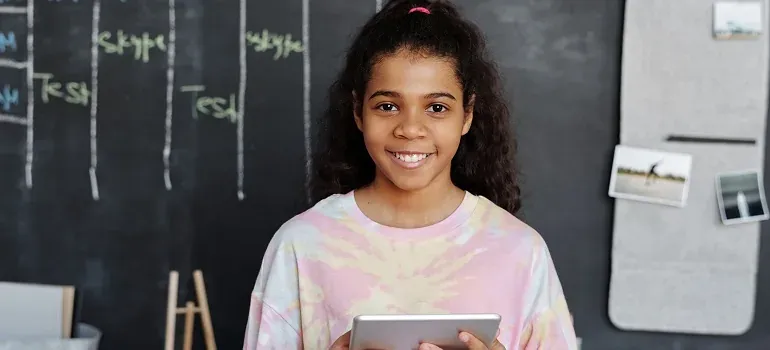Girl with tablet before chalkboard