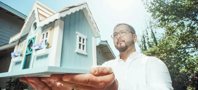 Man holding miniature house model