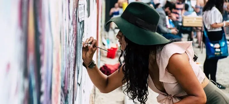 Woman in hat painting mural