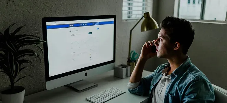 Man on phone at desktop computer