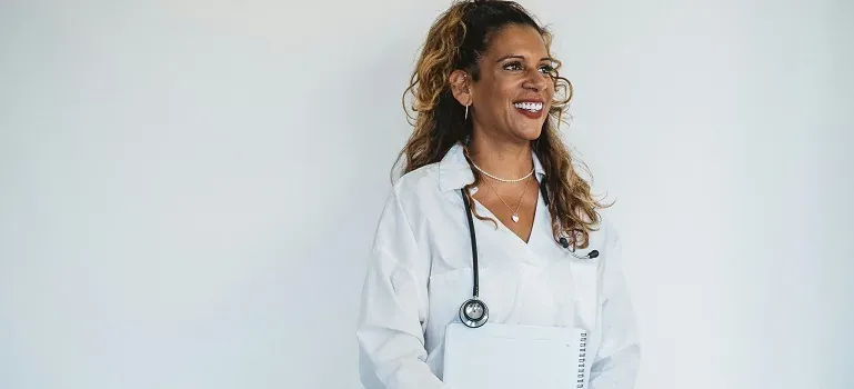 Smiling doctor with stethoscope and notebook