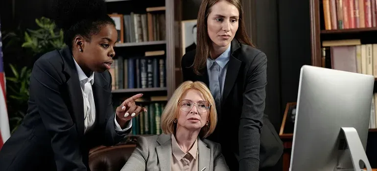 Three businesswomen at computer in office