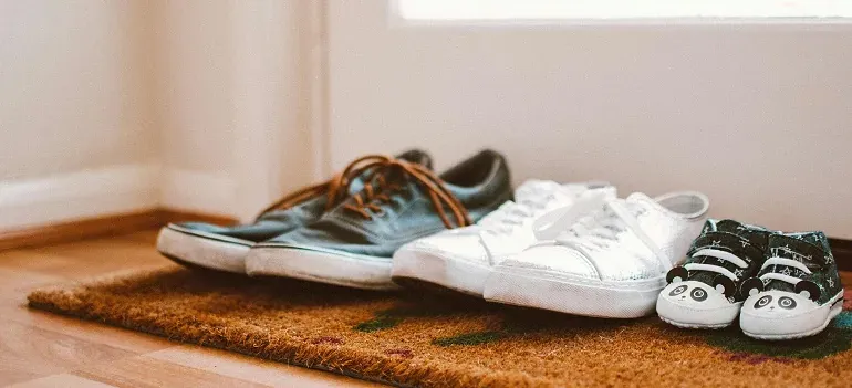 Family shoes lined up on doormat
