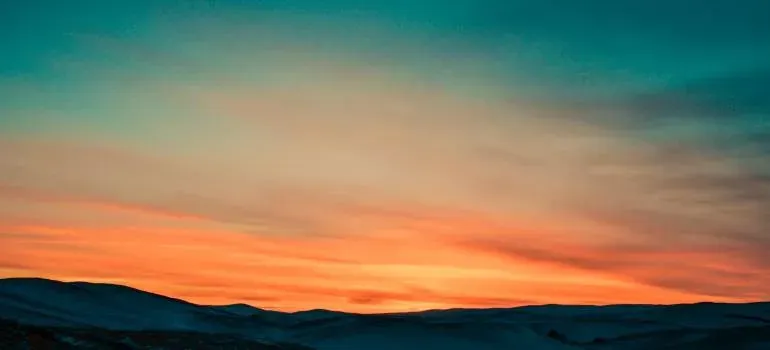 Orange sunset over snowy hills