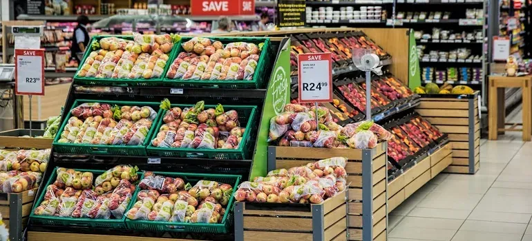 Grocery store produce aisle with SAVE signs