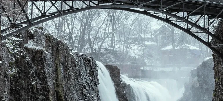 Snowy waterfall under arched bridge