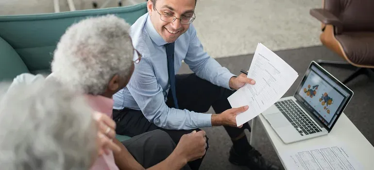 Advisor showing documents to elderly couple