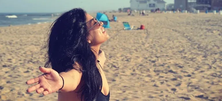 Woman with open arms on beach
