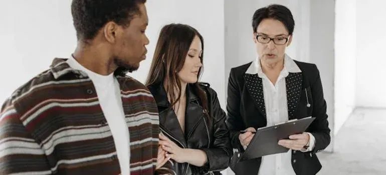 Agent with clipboard talking to couple