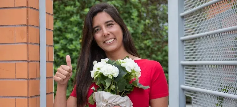 Woman with flowers giving thumbs up