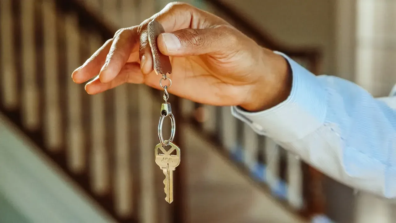 Hand holding house key on keyring