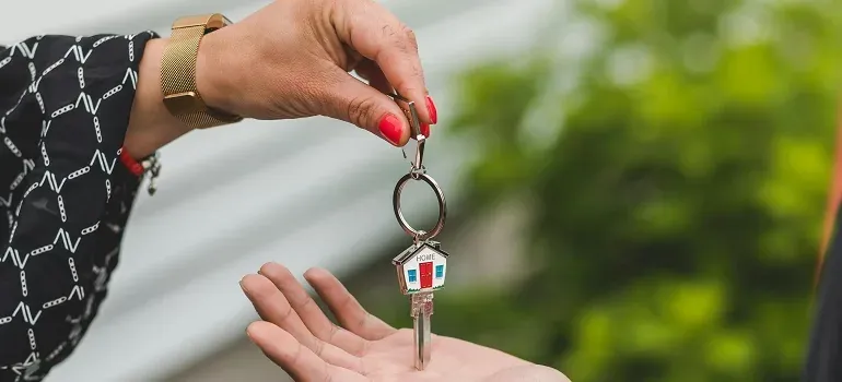 Handing house-shaped key to open palm