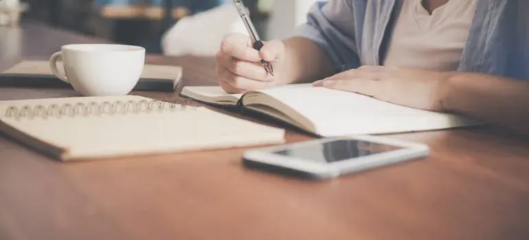 Person writing in notebook at desk