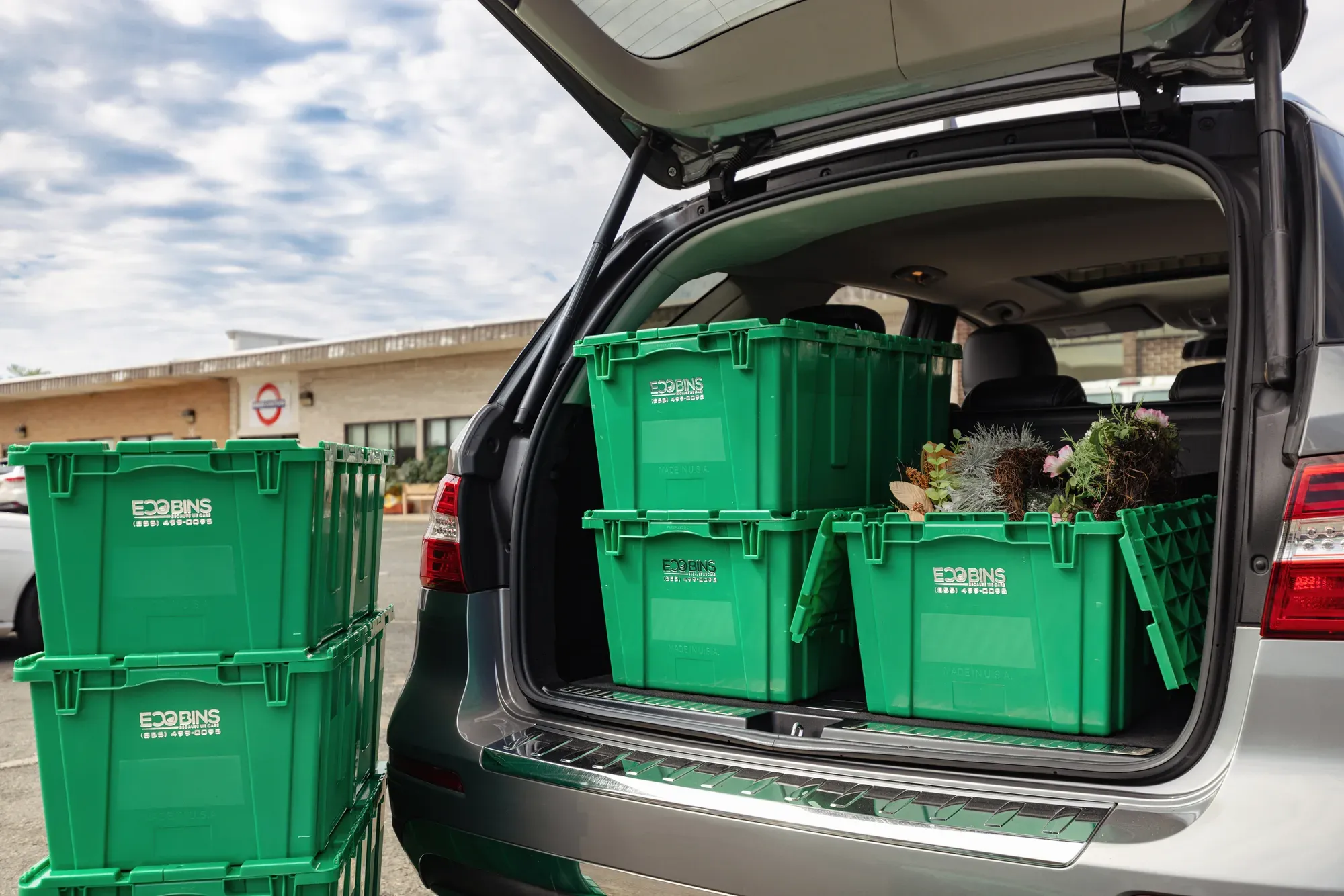 Green EcoBins bins packed and loaded into the back of a car