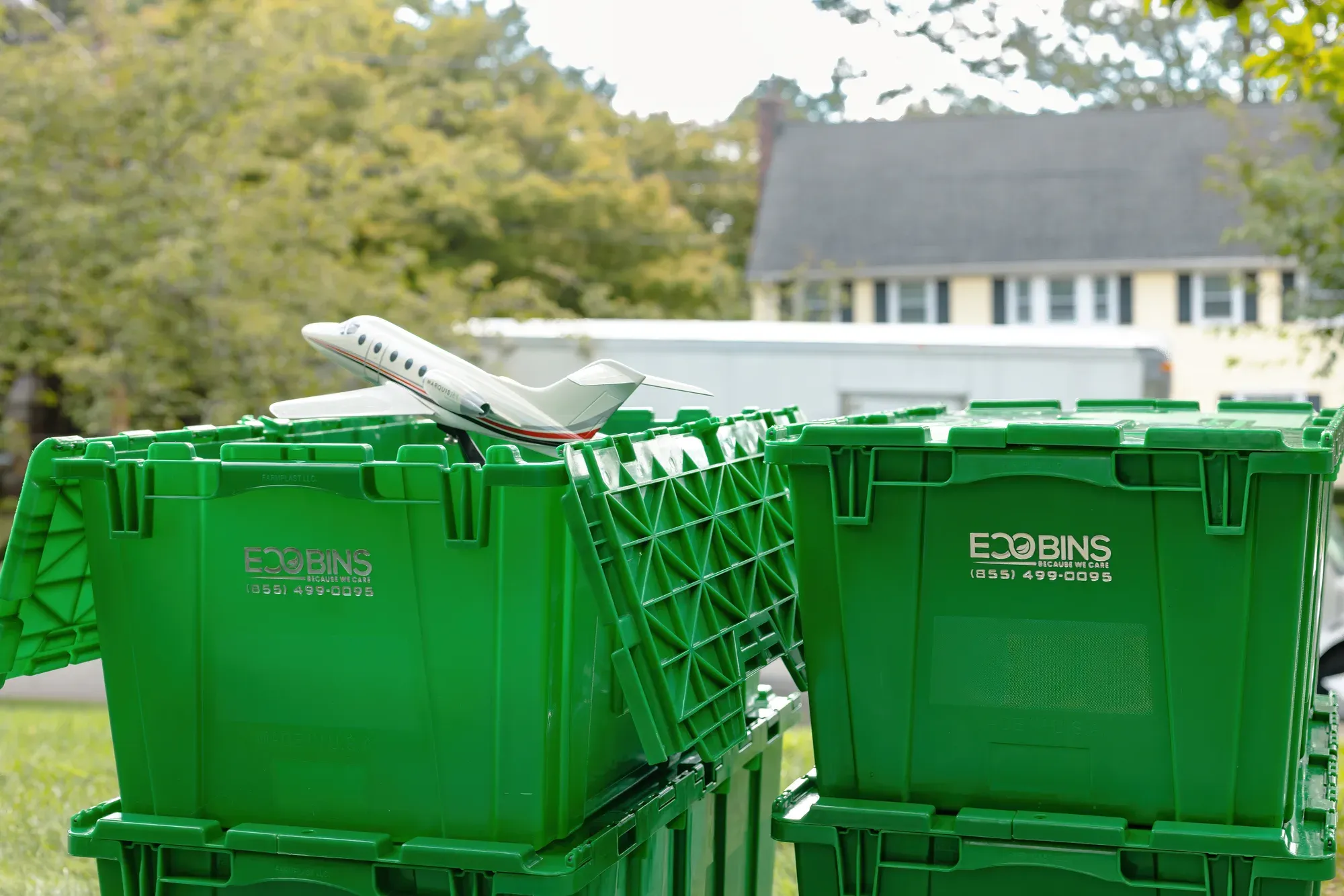 Green EcoBins bins stacked and folded flat, ready for collection