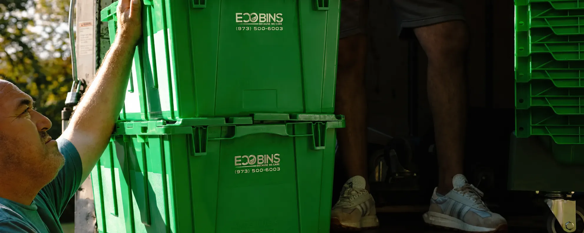 Teddy Bear mover loading green reusable EcoBins onto a moving truck