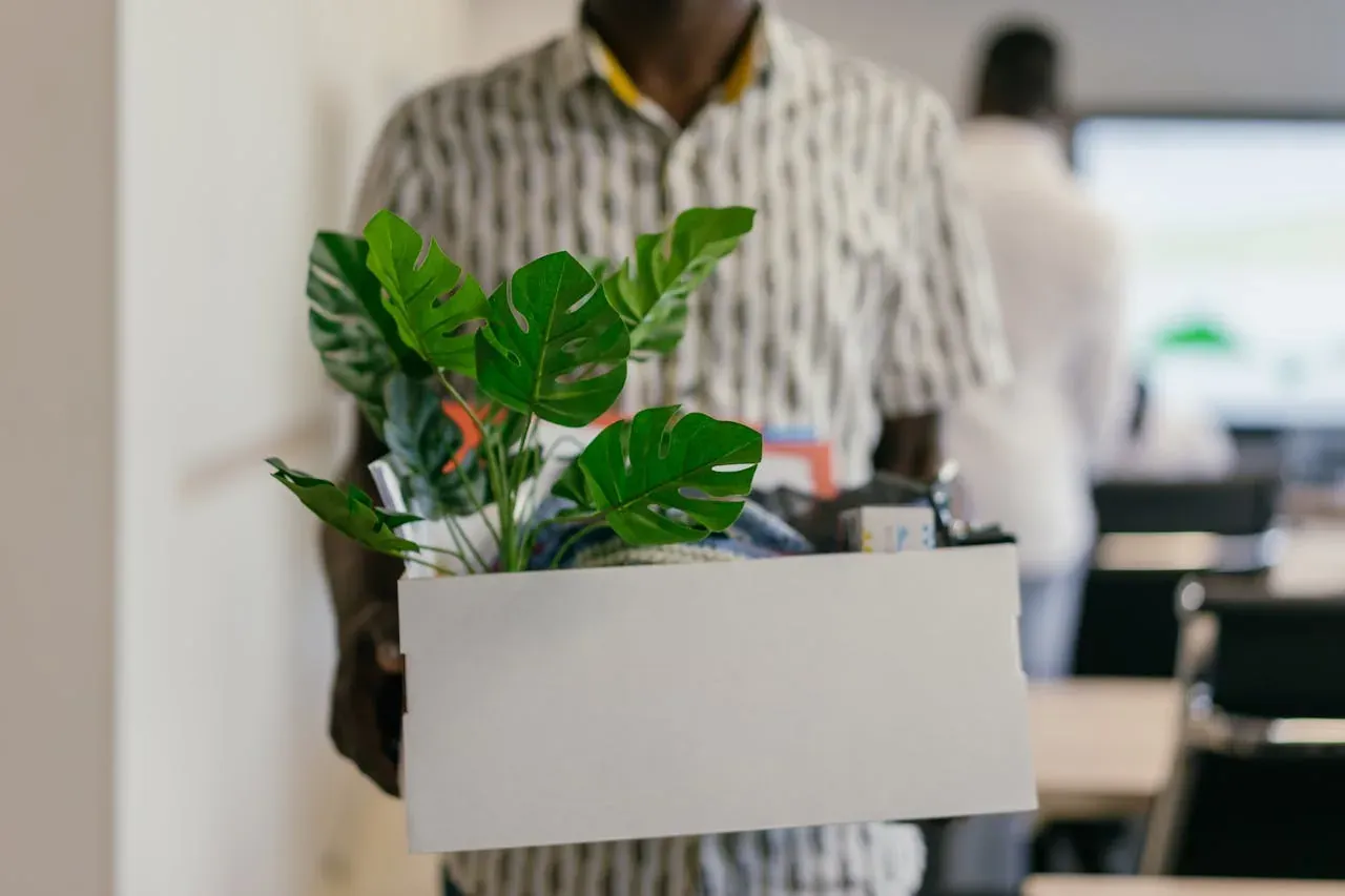 Person carrying office boxes while preparing for a New Jersey job relocation