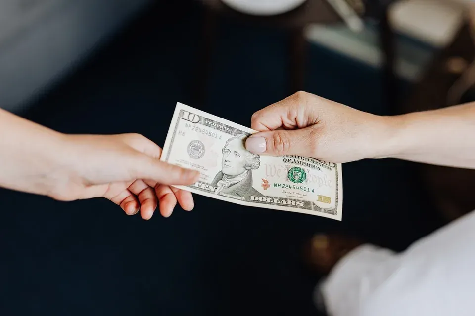 Person counting cash to tip a moving crew