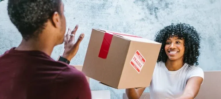 Woman handing fragile box to man
