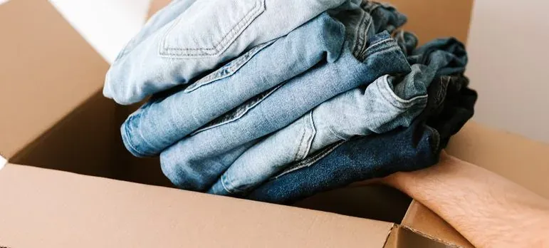 Folded jeans in cardboard box
